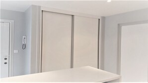 A room with a white door, a white wall-mounted phone, and a white table. - Saint German des-Prés chic and comfortable (Paris)