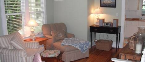 A cozy living room with striped sofas, a beige armchair, and a wooden coffee table.