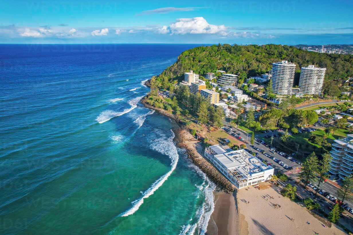 Un hotel frente al mar con varias construcciones, una playa y vistas al océano.
