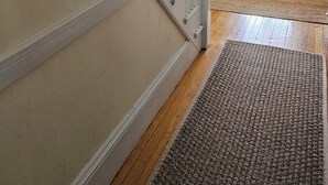 Un escalier avec des rampes blanches menant à une porte dotée d’un panneau de verre.