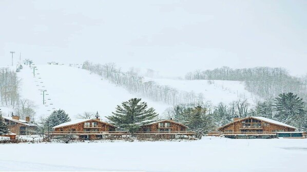 A wooden lodge with a ski lift in the background. - Schuss MOUNTAIN VIEW! golf course Close to lakes pool Temperpedic mattress (Mancelona)