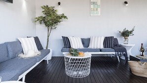 Eine moderne Lounge mit zwei Sofas, einem runden Tisch und einer an der Wand befestigten Beschilderung.