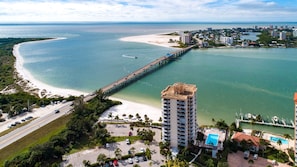 A coastal hotel with a beach view, a pier, and a swimming pool.