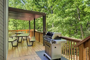A covered deck with picnic tables and a barbecue grill. - Modern Stream-front property with hot tub. (Bushkill)