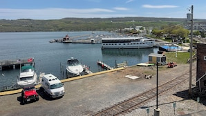 A marina with boats, a ferry, and a train track.