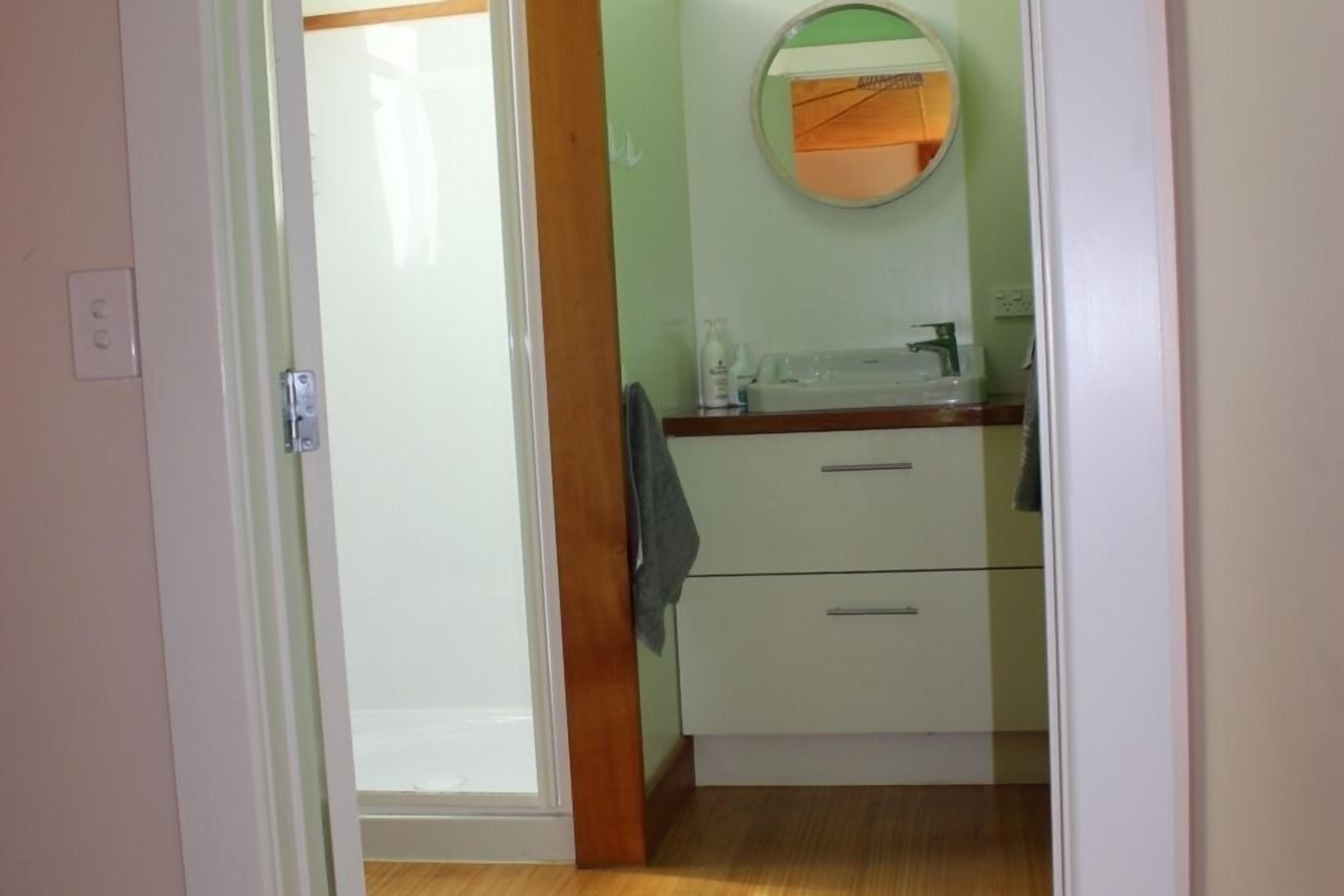 Ein Badezimmer mit Spiegel, Waschbecken und zwei Schubladen.
