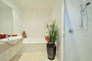 Chuveiro, banheira de hidromassagem, secador de cabelo, toalhas de banho