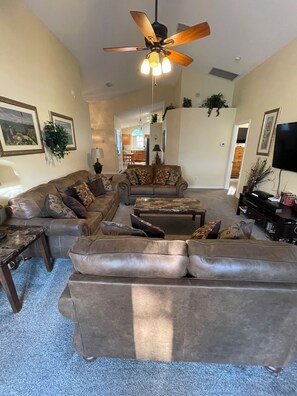 Relax in this inviting living room with a large sofa, coffee table, and floor lamp, perfect for unwinding.