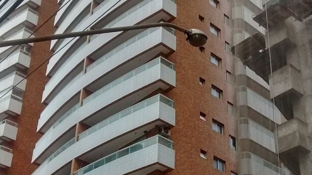Un immeuble résidentiel à plusieurs étages, doté de balcons et d’un lampadaire.