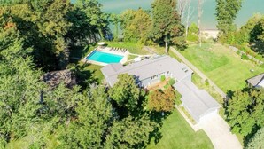 An aerial view of a residential property with a swimming pool, a detached house, and surrounding greenery. - Spa House:On Lake Michigan w/ Pool, Hot Tub, Sauna (Benton Harbor)