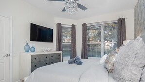 A bedroom with a bed, a TV, a dresser, and a window with curtains. - Luxury 5 Stars Home w/Princess & Mickey Themed Rooms, Game Room Private Pool/Spa (Kissimmee)