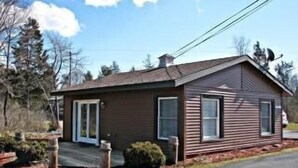 A single-story house with a front porch, a chimney, and a satellite dish.