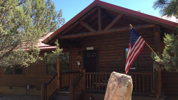 A wooden cabin with a porch, a welcome sign, and an American flag. - Beautiful Bison Ridge Cabin that has it all... (Show Low)
