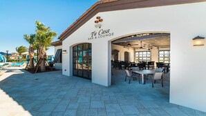 A Tu Casa Bar & Lounge mit Außenbereich und Pool im Hintergrund.