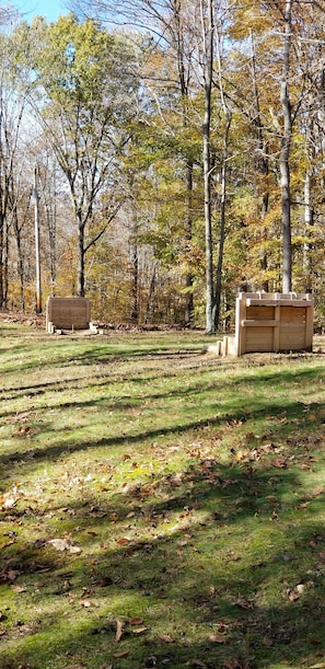 Relax on the lush grass surrounded by vibrant autumn trees and two benches.