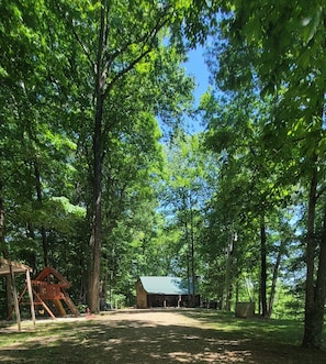 Escape to a serene park setting surrounded by lush trees and a well-maintained grassy area.