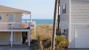 A coastal property with a balcony overlooking the sea, a garage, and a utility pole. - Fun-N-The Sun - 2 BR Home; Dog Friendly with an Ocean View! (Surf City)