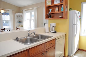 A kitchen with a double sink, a coffee maker, and a refrigerator. - Fun-N-The Sun - 2 BR Home; Dog Friendly with an Ocean View! (Surf City)
