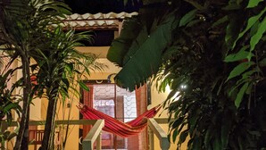 A staircase leading to a building with a red hammock hanging on the railing.