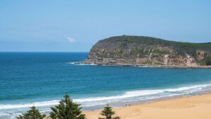 A beach with a rocky cliff and a clear blue sky. - “Oceanview & Seabreeze” - with Pool (Copacabana)