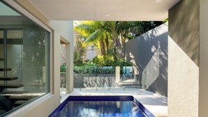 A swimming pool with blue tiles, surrounded by a concrete deck and a glass wall on one side. - “Oceanview & Seabreeze” - with Pool (Copacabana)