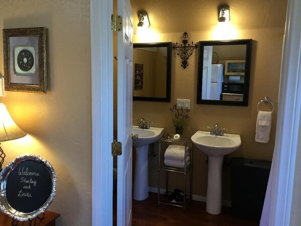 A bathroom with two sinks, a mirror, a towel rack, and a welcome sign. - Tree Top Cottage- Romantic HOT TUB WiFi Pets 145.00/185.00 (Big bear lake)