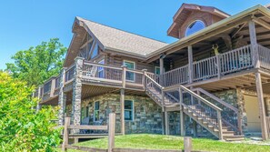 A multi-story house with a stone facade, wooden balconies, and a staircase. - Riverview Log Cabin Lodge Near Creation Museum & Arc Encounter (Union)