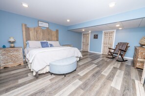 A bedroom with a bed, a bench, a rocking chair, and a dresser. - Riverview Log Cabin Lodge Near Creation Museum & Arc Encounter (Union)