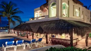 Ein modernes Resort mit Pool, Liegestühlen und einer Bar.