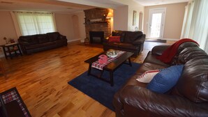 A living room with a fireplace, two sofas, a coffee table, and a rug.