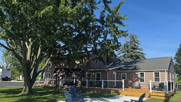 A house with a deck, outdoor seating, and a fire pit.