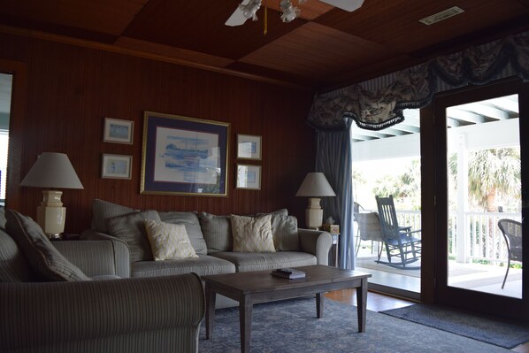 A living room with a sofa, two lamps, a coffee table, and a large framed picture on the wall.