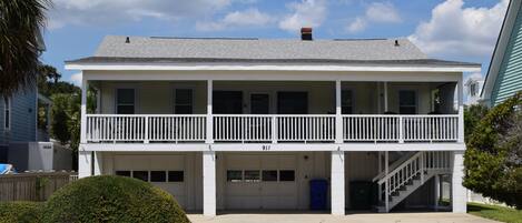 Un bâtiment à deux étages doté d’un balcon, d’un garage et d’un escalier menant à l’étage supérieur.