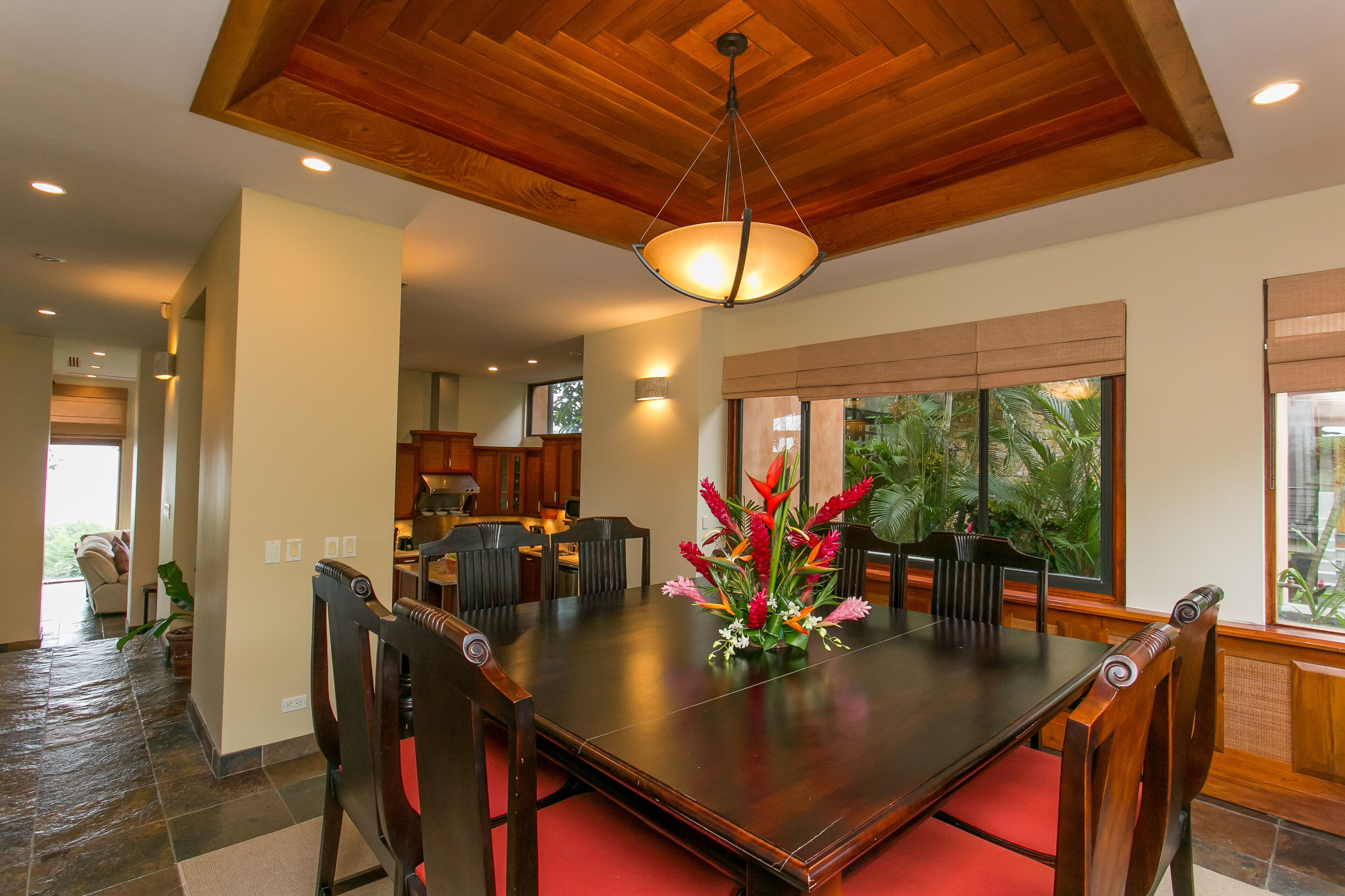 Comedor con mesa de madera, sillas y lámpara colgante.