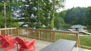Enjoy a serene waterfront setting with a picnic table and Adirondack chairs on the deck overlooking the water.