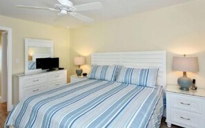 A bedroom with a bed, nightstands, a television, and a ceiling fan. - Firethorn 322-Beachfront 2BR/1.5BA condo on gorgeous Siesta key (Siesta Key)