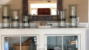 Eine Küche mit dekorativer Spritzschutzleiste, einer Holzschüssel und Glasbehältern auf der Arbeitsfläche.