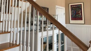 Eine mehrstufige Holztreppe mit weißen Stakobenen und einem Holzgeländer.