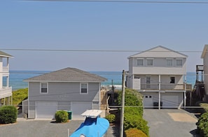 Zona residencial à beira-mar, com casas, céu limpo e vista para o oceano.