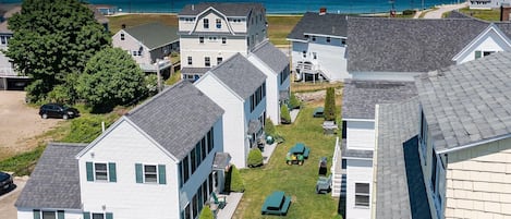A residential area with houses, a lawn, and a view of the ocean.