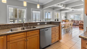 A kitchen with granite countertops, wooden cabinets, a dishwasher, and pendant lighting. - Cottagevacations4u "Island Dunes" Villa ocean view- elevator- pool club-pickleball-tennis (Ocean Isle Beach)