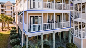 A multi-story hotel with balconies, a covered outdoor area, and a poolside deck. - Cottagevacations4u "Island Dunes" Villa ocean view- elevator- pool club-pickleball-tennis (Ocean Isle Beach)
