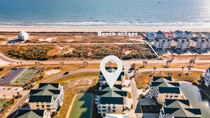 An aerial view of a coastal hotel with beach access, featuring multiple buildings with green roofs and a clear view of the ocean. - Cottagevacations4u "Island Dunes" Villa ocean view- elevator- pool club-pickleball-tennis (Ocean Isle Beach)