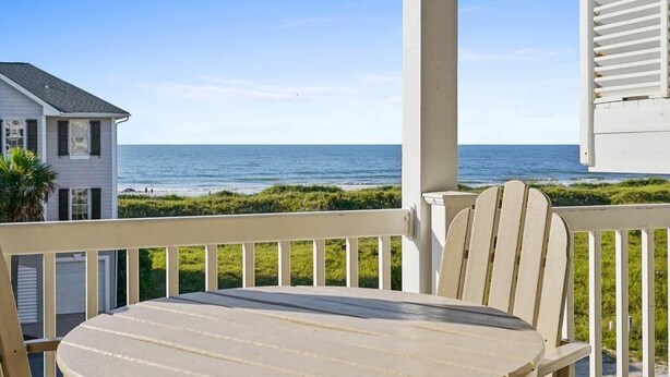 A balcony with a view of the ocean, a table, and chairs. - CottageVacations4u "BEACH HAVEN"  ocean view-pool club-direct access to beach-dog friendly (Ocean Isle Beach)