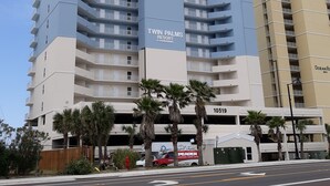 Un immeuble de grande hauteur, orné d’un logo bien visible et du nom « Twin Palms Resort » sur sa façade.