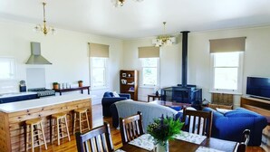 A spacious living area with a kitchen, dining table, and seating.