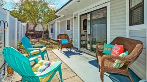 A patio area with outdoor furniture, a covered entryway, and a sliding glass door leading to a garage.