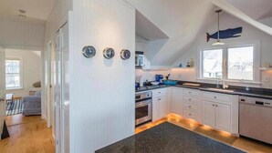 Una cocina moderna con armarios blancos, encimera de granito y horno empotrado.