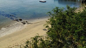 Una playa con barcos, un muelle y una orilla arenosa.