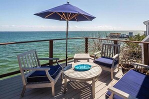 Eine Terrasse mit zwei Stühlen, einem Tisch und einem blauen Sonnenschirm.